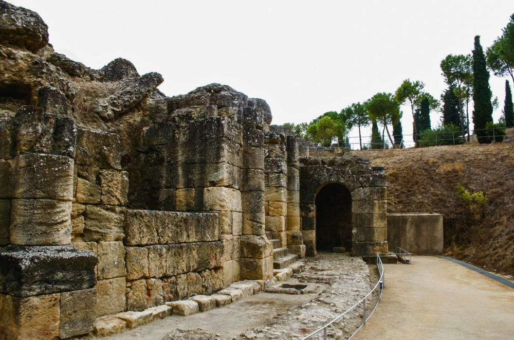 Well-preserved stone archway entrance to Italica's Roman amphitheater.
