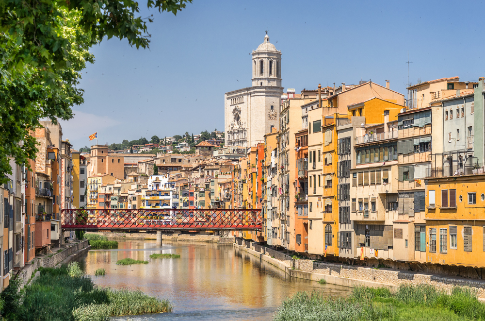 Iconic bridge spanning Onyar River with riverside houses.