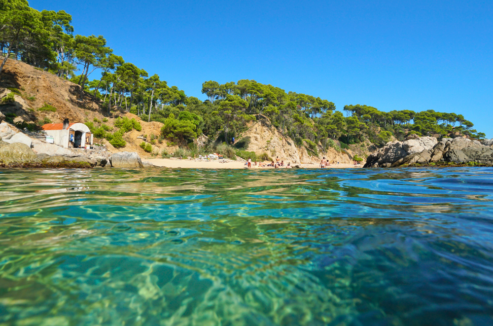 Cala Estreta beach with its Crystal clear turquoise water sand a small sandy shore. One of the best beaches in Costa Brava