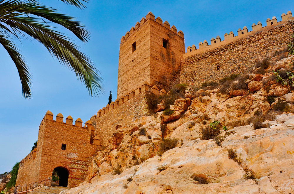 The towers and walls of the Alcazaba fortress rise over Almeria's rocky terrain