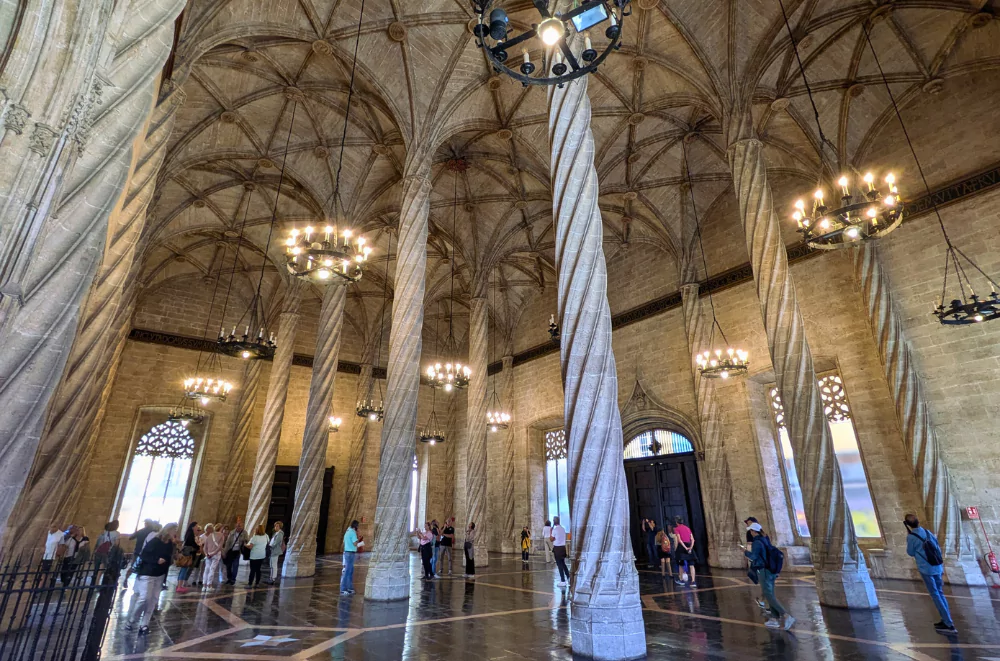 La Lonja's Contract Hall in Valencia old town, featuring twisted Gothic columns and vaulted ceiling with elegant chandeliers