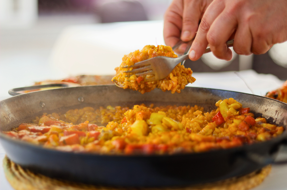 Authentic paella being served from a traditional pan