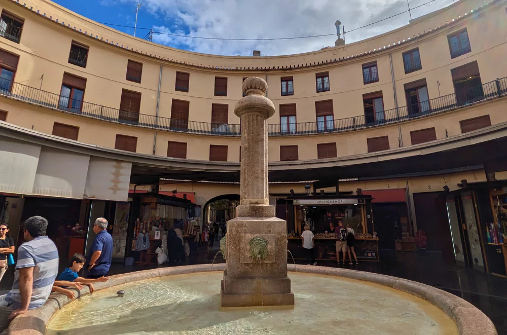 Plaza Redonda in Valencia old town, showing its unique circular design with central fountain and traditional shopping arcades