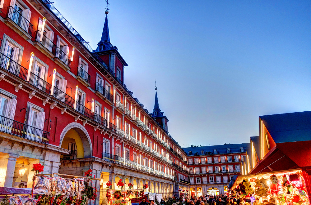 Plaza Mayor in Madrid at night with Christmas market stalls and festive decorations